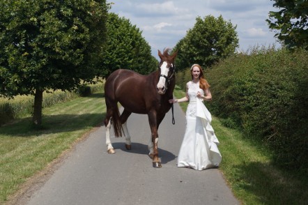 Sophie in her wedding dress with a horse.