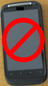Photograph of a smart phone with a no entry sign on top of it