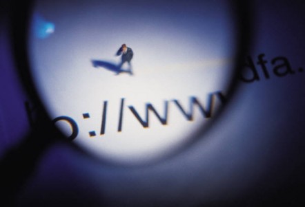 Magnifying glass held over a website address and a figurine of man