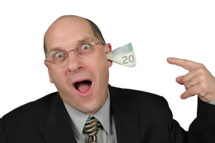 Bald man in a suit shouting with a 20 note in his ear