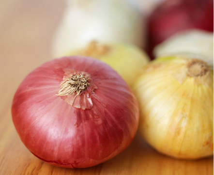 Red and white onions on a wooden worktop