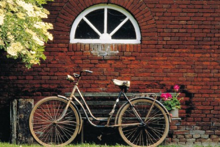 an old bycycle resting on a brick wall