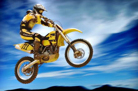A person in yellow leathers riding a yellow dirt bike
