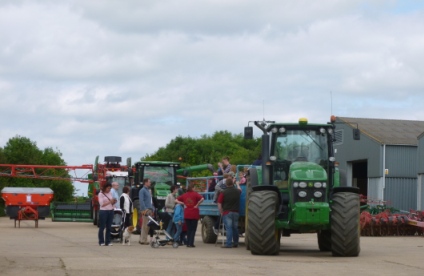 People queing for a trailor pulled by a green John Deer