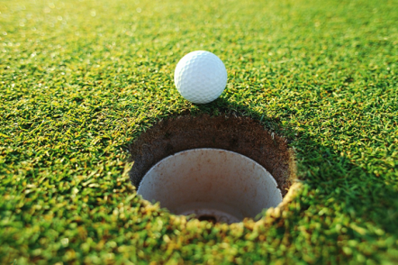 A golf ball by a hole