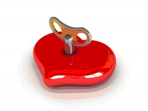 A red heart shaped toy with a key in it.