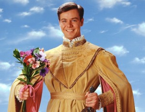 Man in medieval costume holding a bunch of flowers.