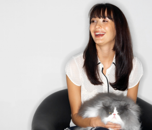 woman laughing and holding a cat