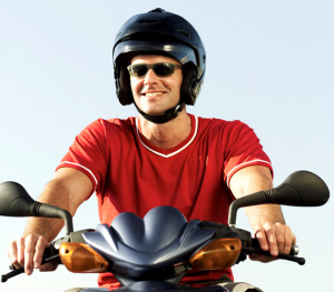 Man wearing sunglasses and a helmet on a scooter
