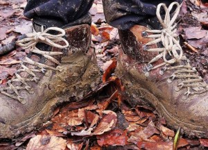 Mud covered walking boots on autumn leaves