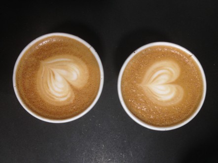 two cups of latte with heart shapes on top