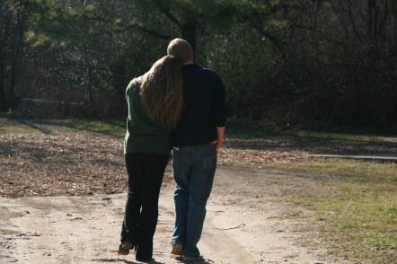 woman and man walking together in the woods